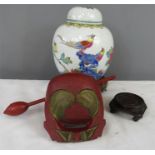 A Chinese ginger jar and cover raised on a carved stand, together with a further stand, and a