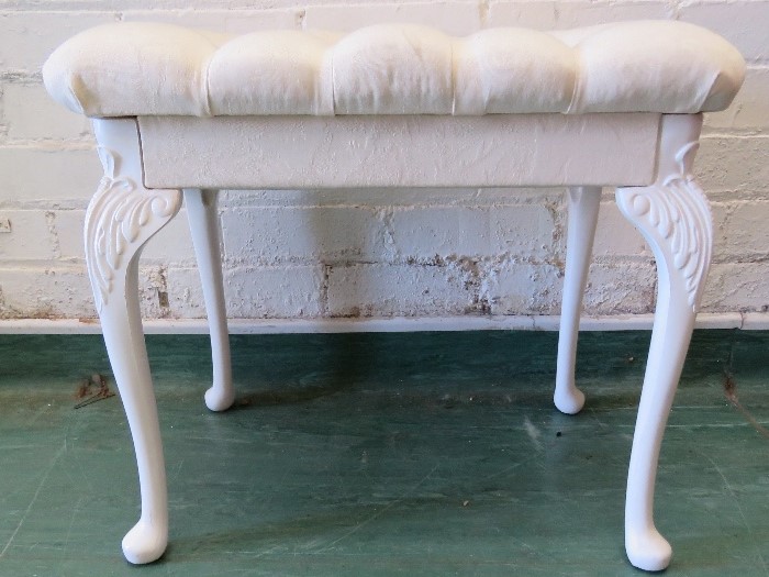 A white painted stool with cabriole legs, and buttoned seat.