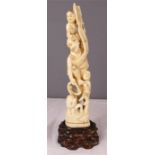 A 19th century carved ivory tusk in the form of fisherman and children at the clutches of an