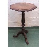 A Victorian oak wine table with octagonal top and carved tripod base.