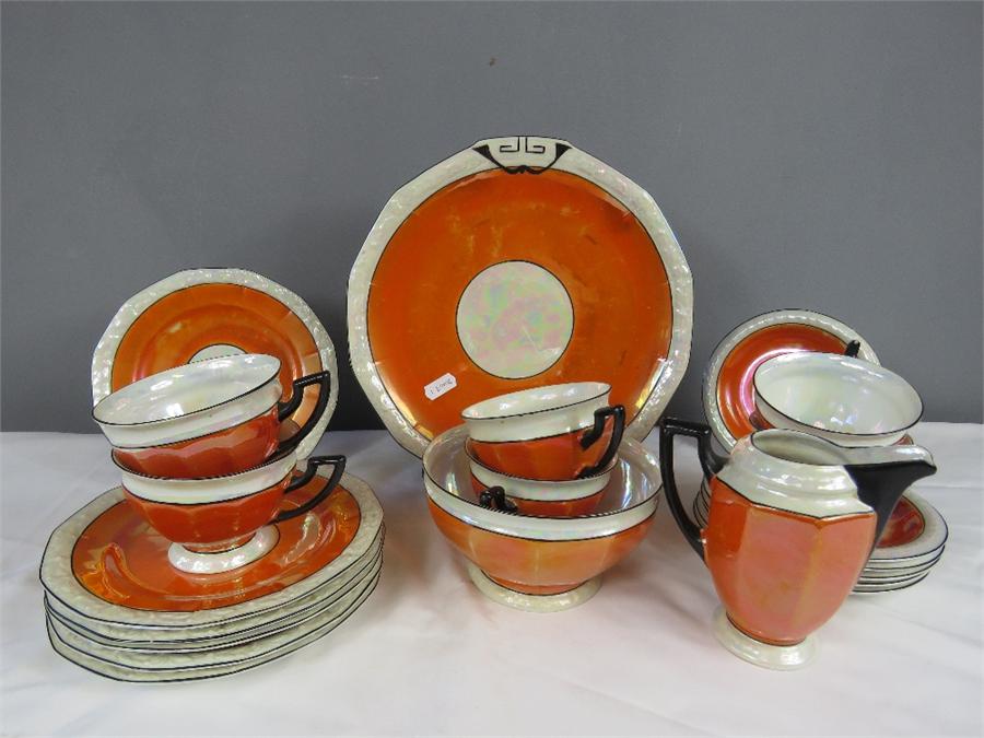 A Czechoslovakian part tea service, with orange lustre glaze, comprising milk jug, sugar bowl, six