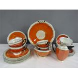A Czechoslovakian part tea service, with orange lustre glaze, comprising milk jug, sugar bowl, six