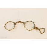 A pair of 19th century silver-gilt folding eye glasses with engraved decoration and shaped handle.