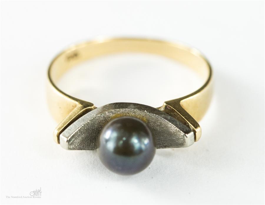 A 9ct gold ring centred with a black pearl, size K, 2.7g.