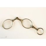 A pair of 19th century silver engraved folding eye glasses with loop handle.
