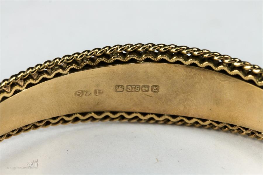 A 9ct gold bangle with a safety chain, 15.4g. - Image 2 of 2