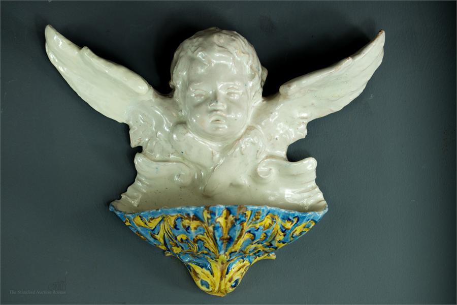 A Faience cherub wall sconce.