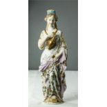 A German porcelain candlestick in the form of a lady carrying ewer and chalice, circa 1890, 35cm