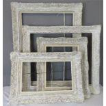 A group of four white painted carved frames of various size.