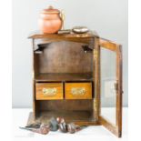 An oak 1950s smokers cabinet with glazed door, interior drawers and contents including a quantity of