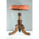 A mahogany carved and gilded piano stool, with height adjustable upholstered circular seat.