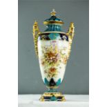 A porcelain urn and cover, painted with flowers, and having gilded twin handles and highlights.