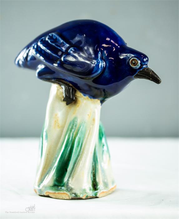 An unusual 19th century blue glazed stoneware bird, raised on a green glazed base.