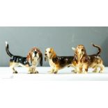 A group of three ceramic Bassett Hounds, one Goebel.