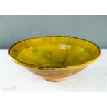 A glazed stoneware bowl, yellow glaze.