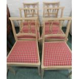 A set of six painted chairs with checkered drop in seat.