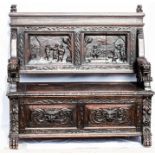 A 17th century style oak settle, with lion head carved arms, relief carved figural panel back and