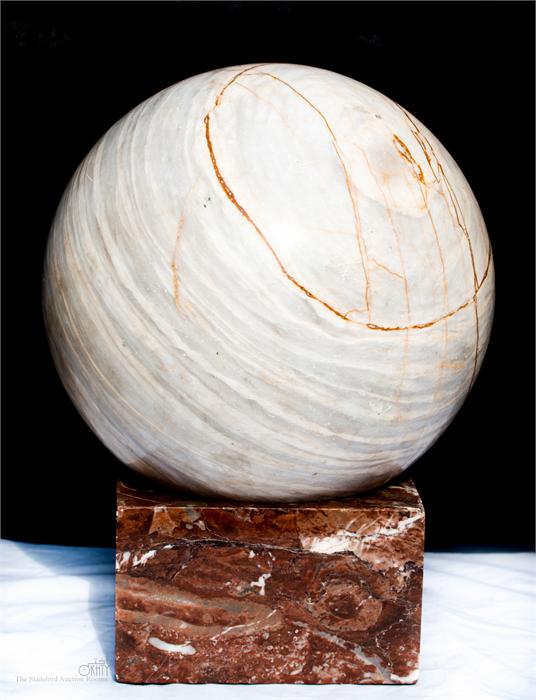 A marble sphere on red marble base, 34cm high.