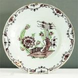 A manganese glazed plate depicting flowers in a garden.