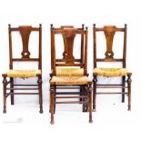 A harlequin set of oak Arts & Crafts style chairs, with rush seats, and pierced with heart.