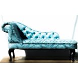 A small chaise longue, upholstered in blue.