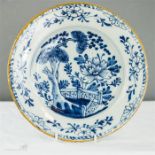 An 18th century blue and white delft plate with yellow rim.