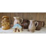 A group of glazed stoneware jugs including a character jug.