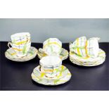 A six piece China part tea service with green and yellow stripes.