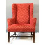 A late 18th/early 19th century wingback armchair, upholstered in red.