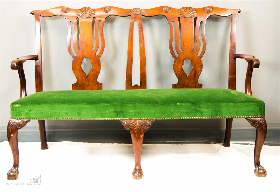 A George II walnut settee, with scallop shell motif, pierced splats, cabriole legs and ball & claw