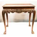 A carved silver/tea table, the tray top with re-entrant corners above shaped and relief carved