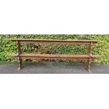 A pair of 19th century long benches, with shaped end boards, morticed through, and raised on