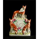 A 19th century Staffordshire fox clock group., 22 by 15cm.