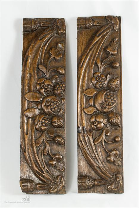 A pair of carved oak panels depicting pomegranites.