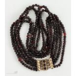 A Victorian garnet necklace composed of four strands, with a 9ct gold decorative clasp.