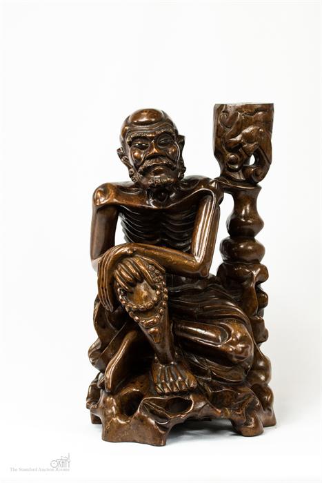 A Chinese carving of a seated man.