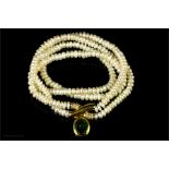 An 18ct gold and pearl necklace set with a diamond and green stone clasp.