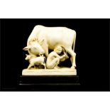 A 19th century ivory Indian carved group, seated maid milking a cow, with calf.