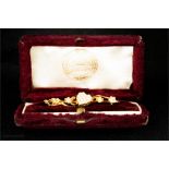 An unmarked gold Victorian brooch with hearts and flowers encrusted with seed pearls, in original