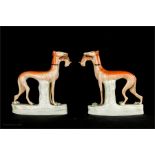 A pair of 19th century Staffordshire greyhounds carrying rabbits, circa 1860, 15cm high.