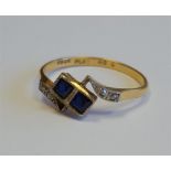 An 18ct gold, sapphire and diamond ring, square cut sapphires set in platinum, 1.8g.