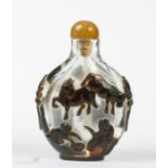 A Chinese glass scent bottle, carved to depict horses and monkeys.