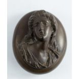 A 19th century treen locket carved in relief to depict a female head and shoulder portrait, the