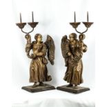 A pair of carved candlesticks, in the form of angels holding cornucopia, 58 by 28cm.