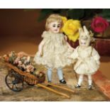Fine Vignette of All-Bisque Dolls with Original Costumes, with Wheeled Flower Cart 1800/2500