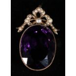 Edwardian large amethyst and seed pearl pendant, the oval cut amethyst measuring 3cm x 2.1cm,