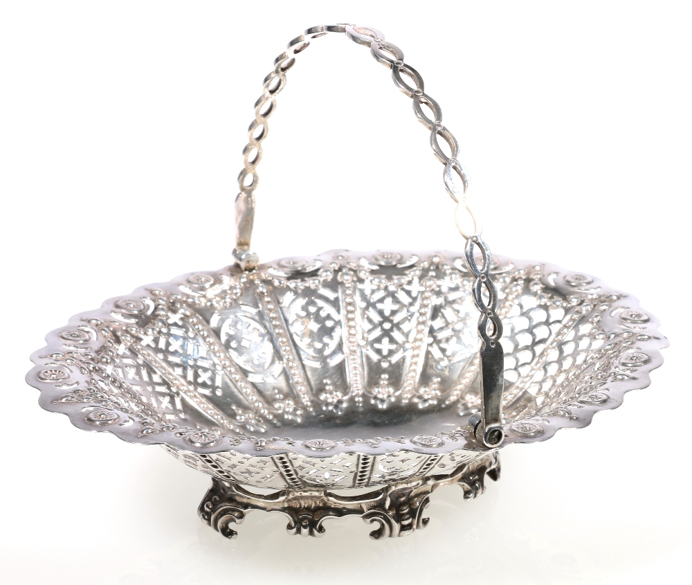 Victorian and silver pierced basket with swing handle and raised on c-scroll feet, makers Martin,