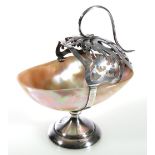 Silver mounted mother-of-pearl table salt, the pierced basket support with scroll handle,