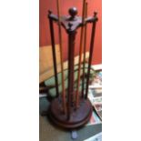 Circular mahogany nineteen-cue snooker cue stand with globe finials.