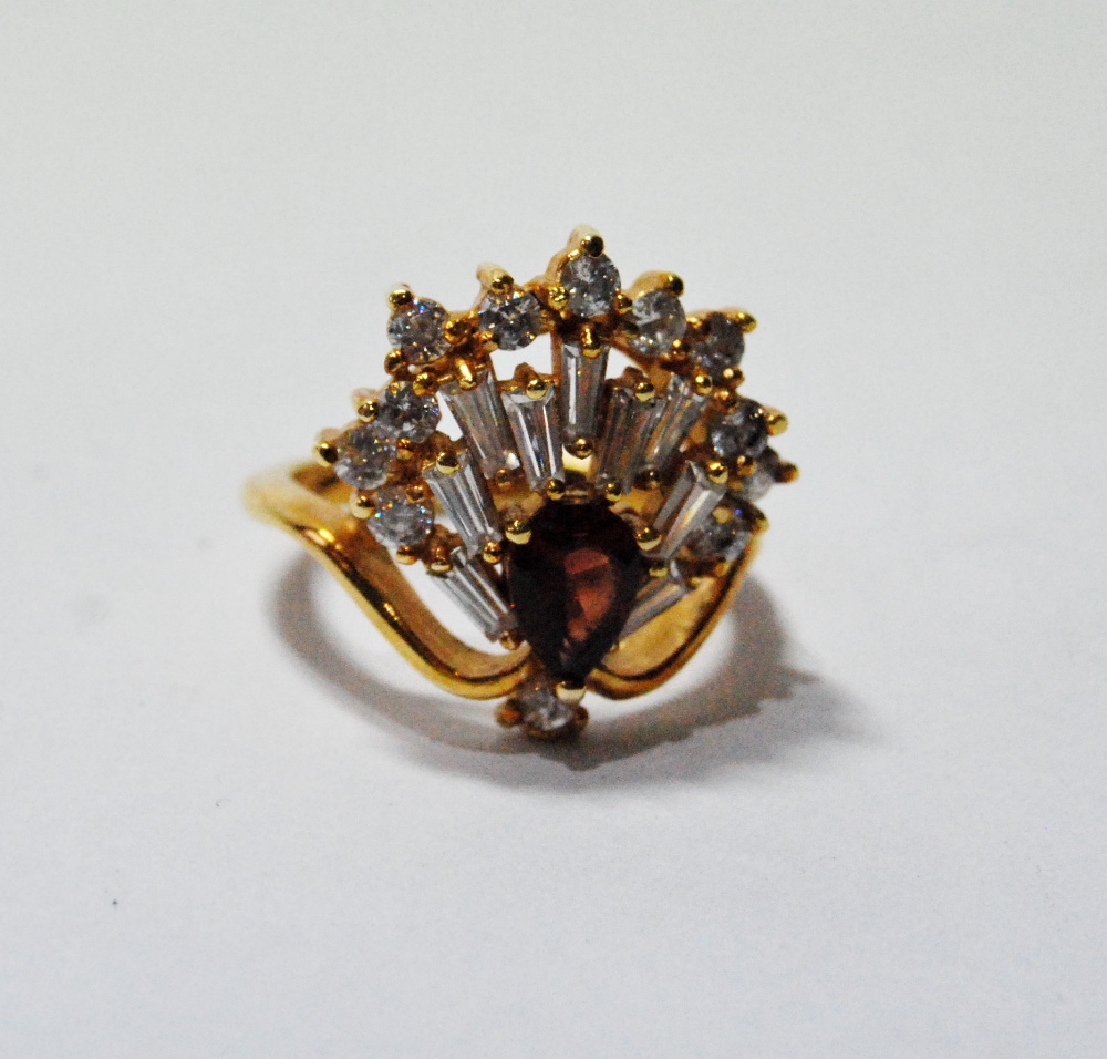 Dress ring with a hessonite garnet with a fan of baguette and brilliant white sapphires, in gold,